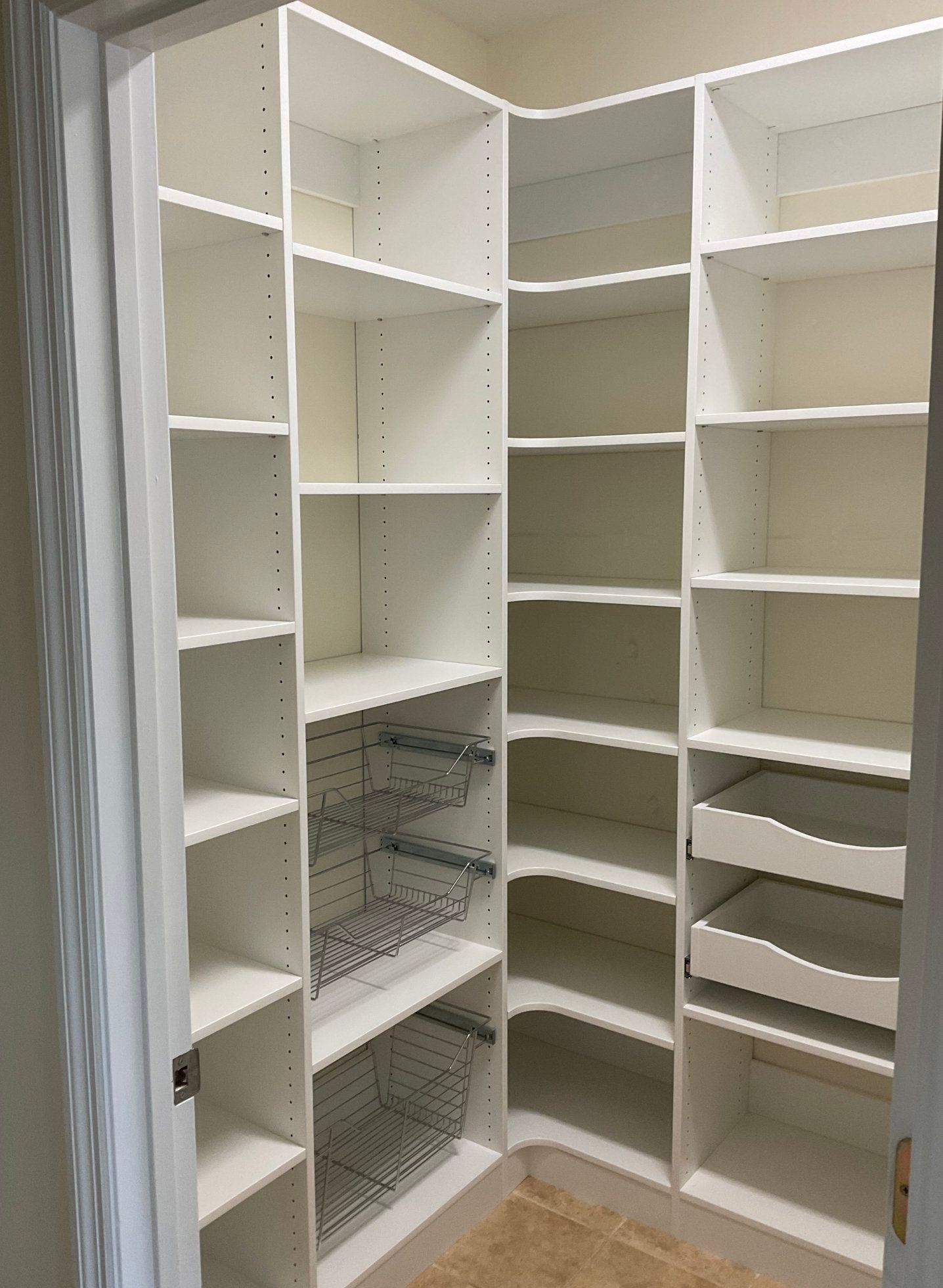 A walk in closet with lots of shelves and drawers.
