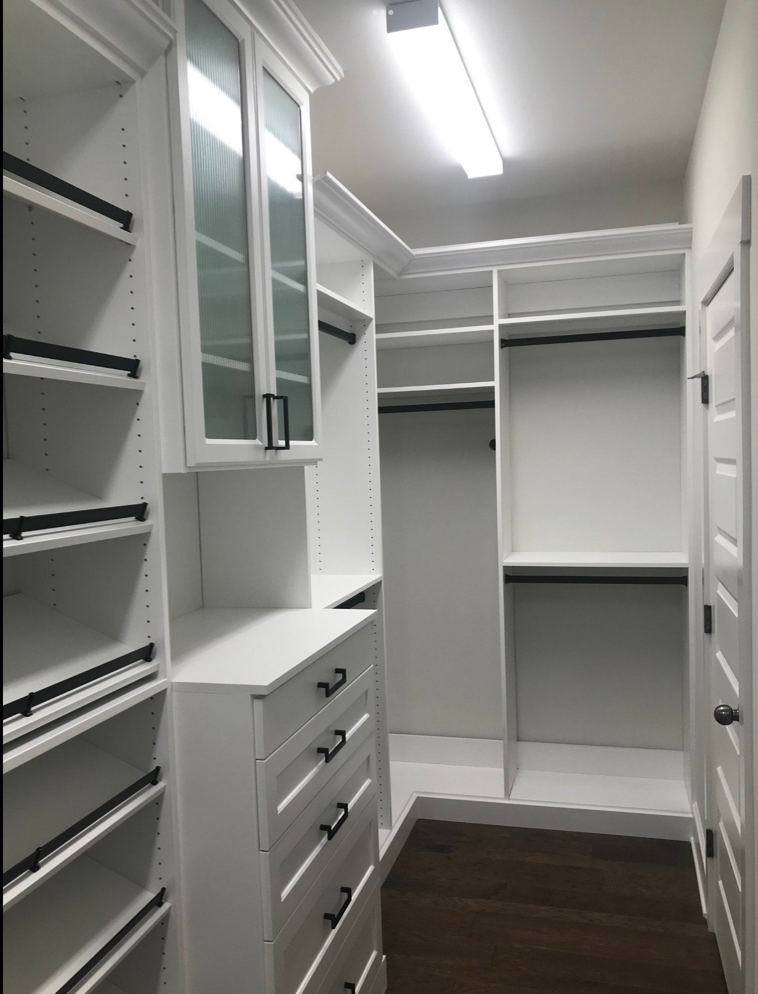 A walk in closet with lots of shelves and drawers