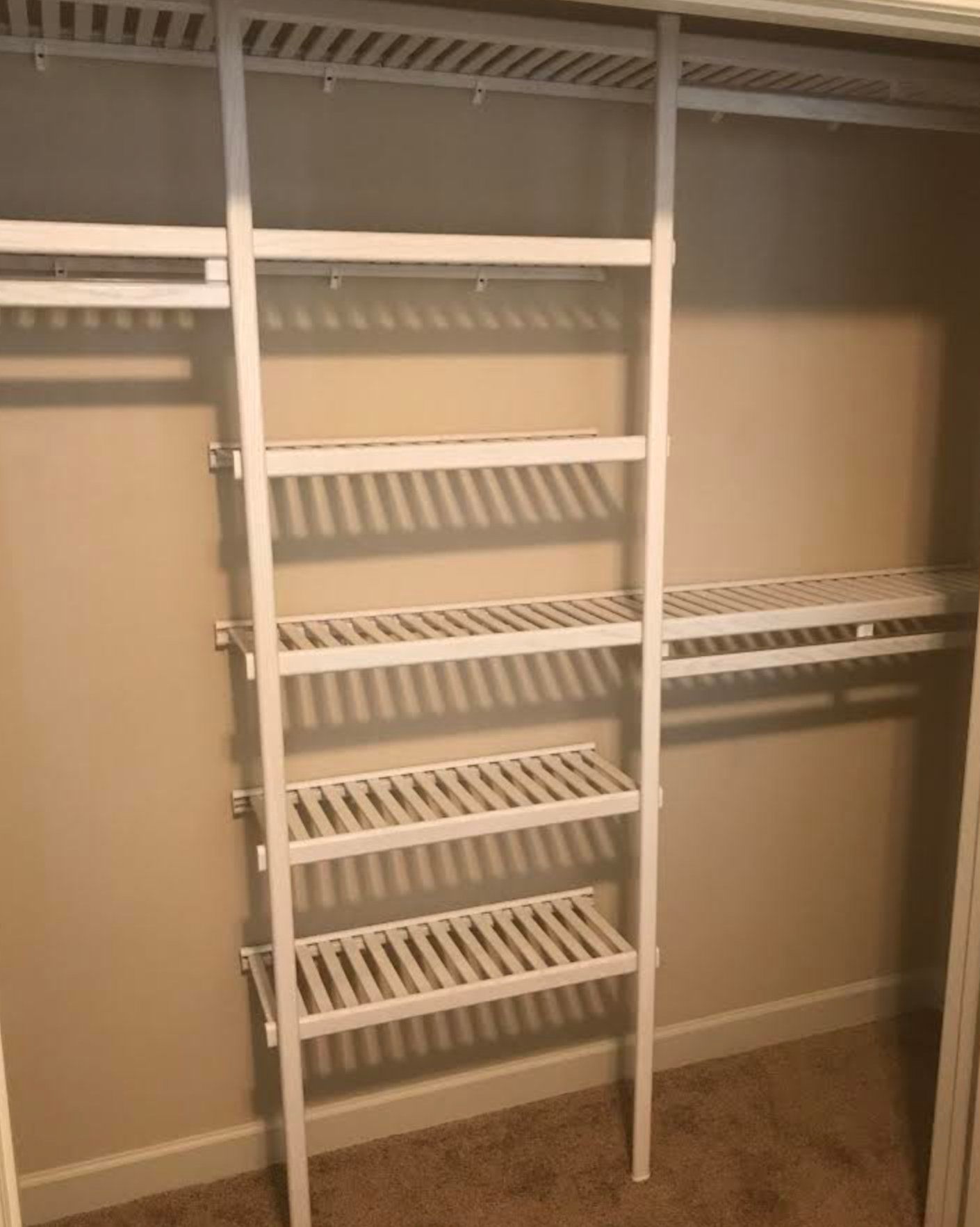 A closet with a ladder and shelves in it.