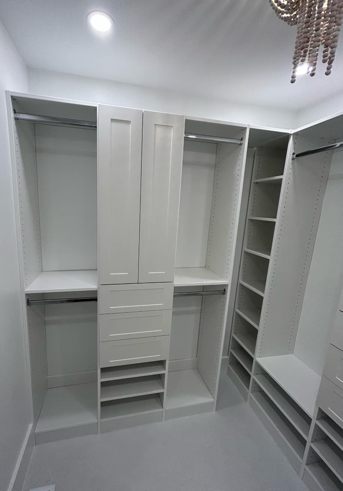 A walk in closet with lots of shelves and drawers.