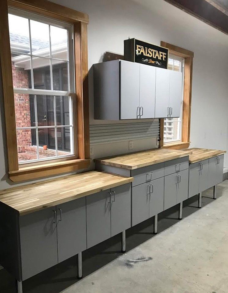 A garage with a lot of cabinets and wooden counter tops.