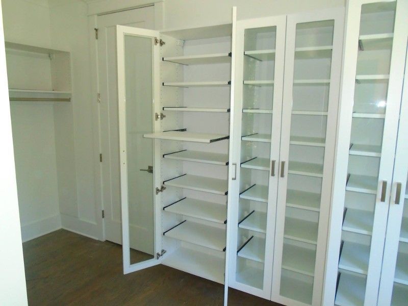 A closet with lots of shelves and glass doors