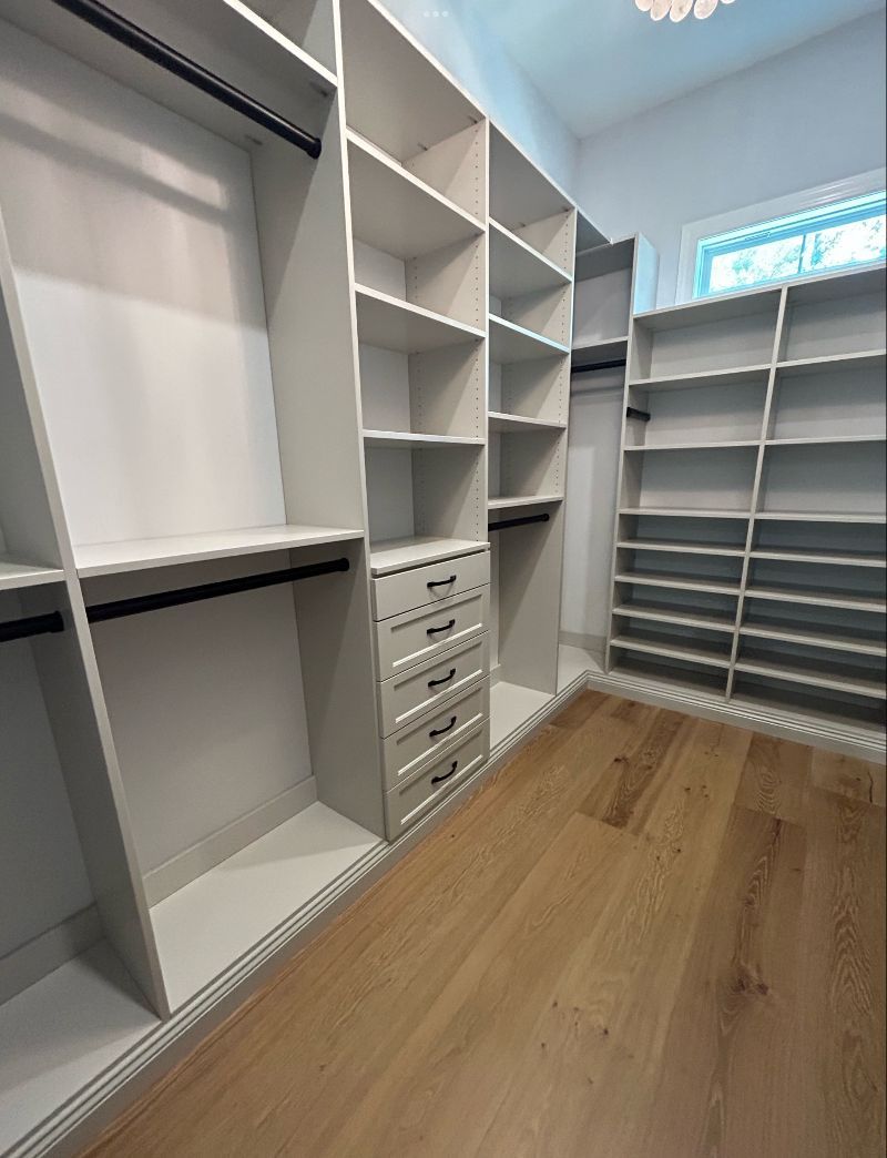 A walk in closet with lots of shelves and drawers.
