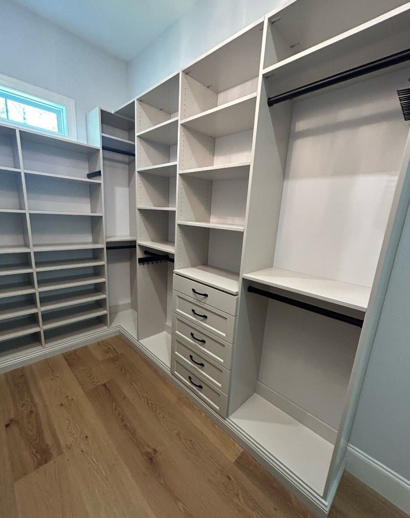 A walk in closet with lots of shelves and drawers.