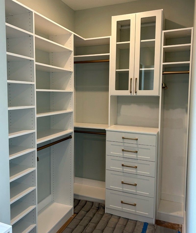 A walk in closet with lots of shelves and drawers.