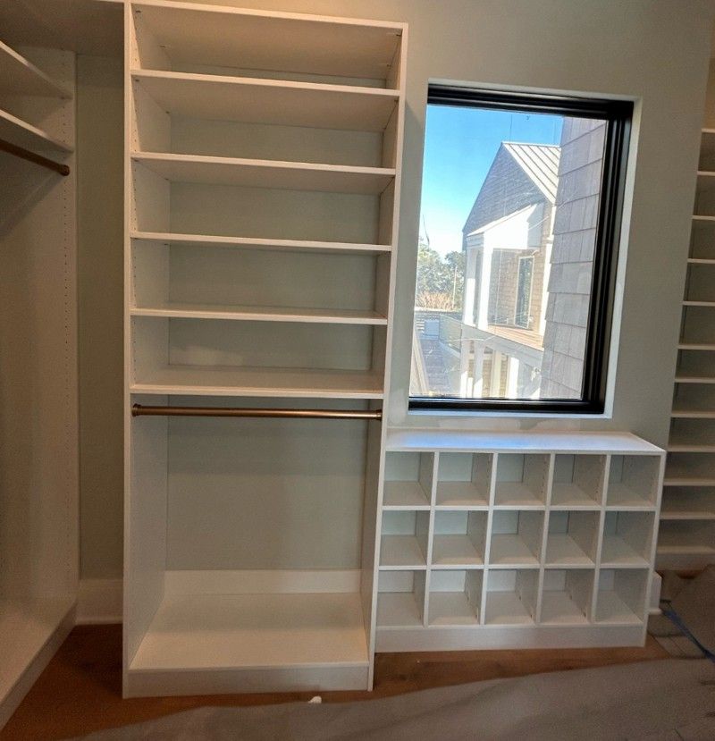 A closet with lots of shelves and a window