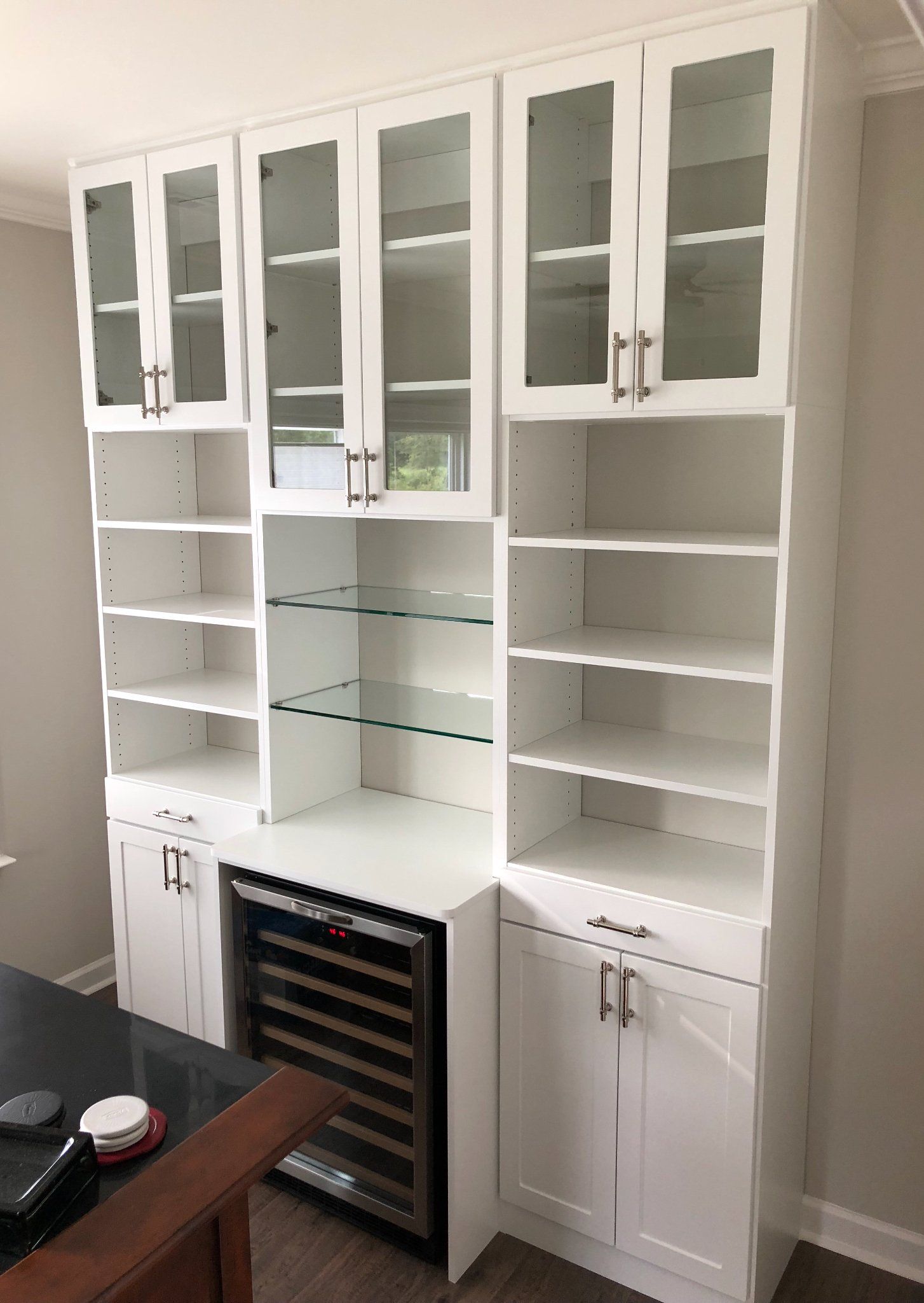 There is a wine cooler in the middle of the cabinets.