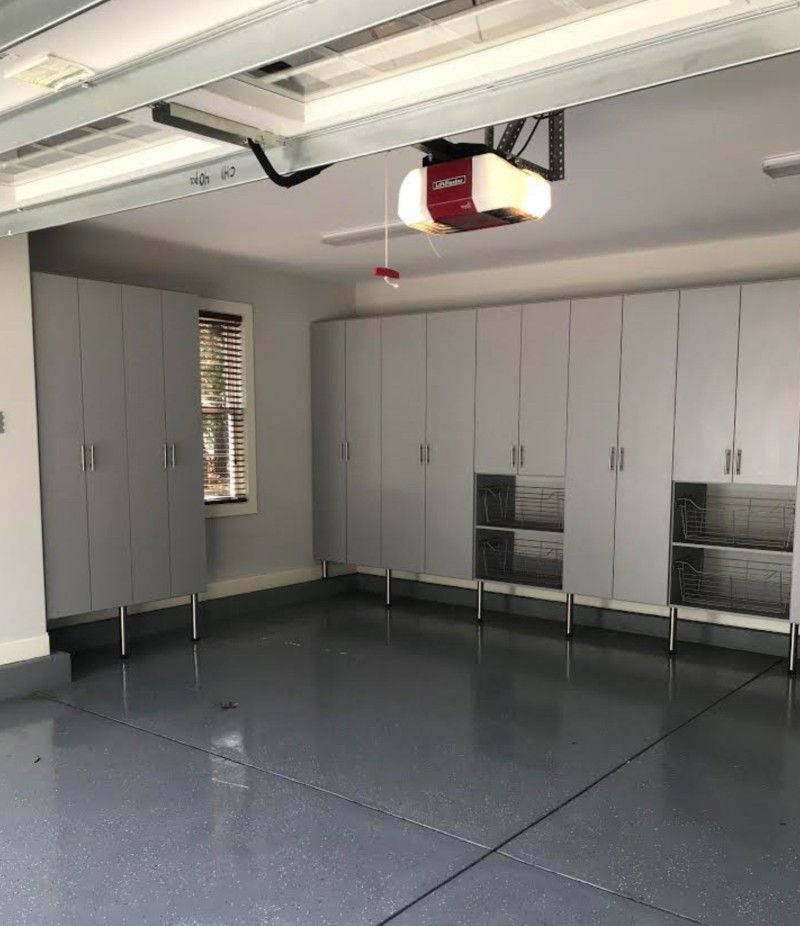 A garage with lots of cabinets and a garage door opener.