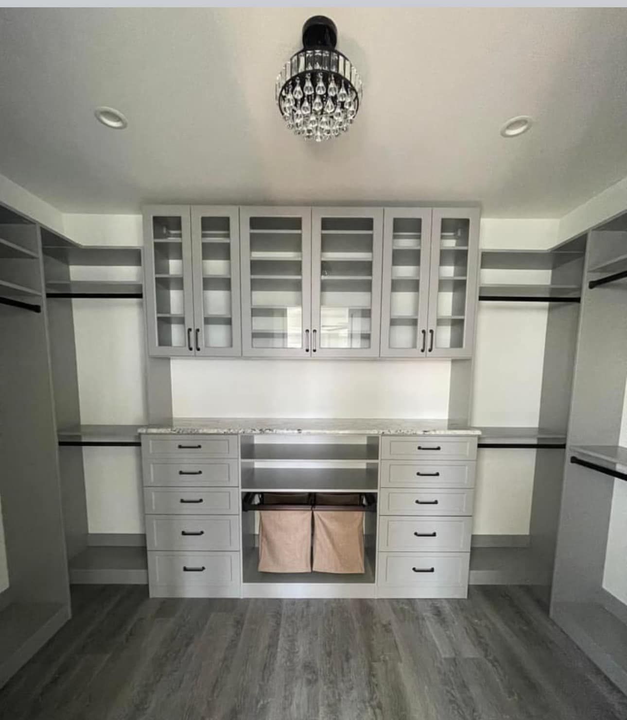 A walk in closet with lots of drawers and cabinets