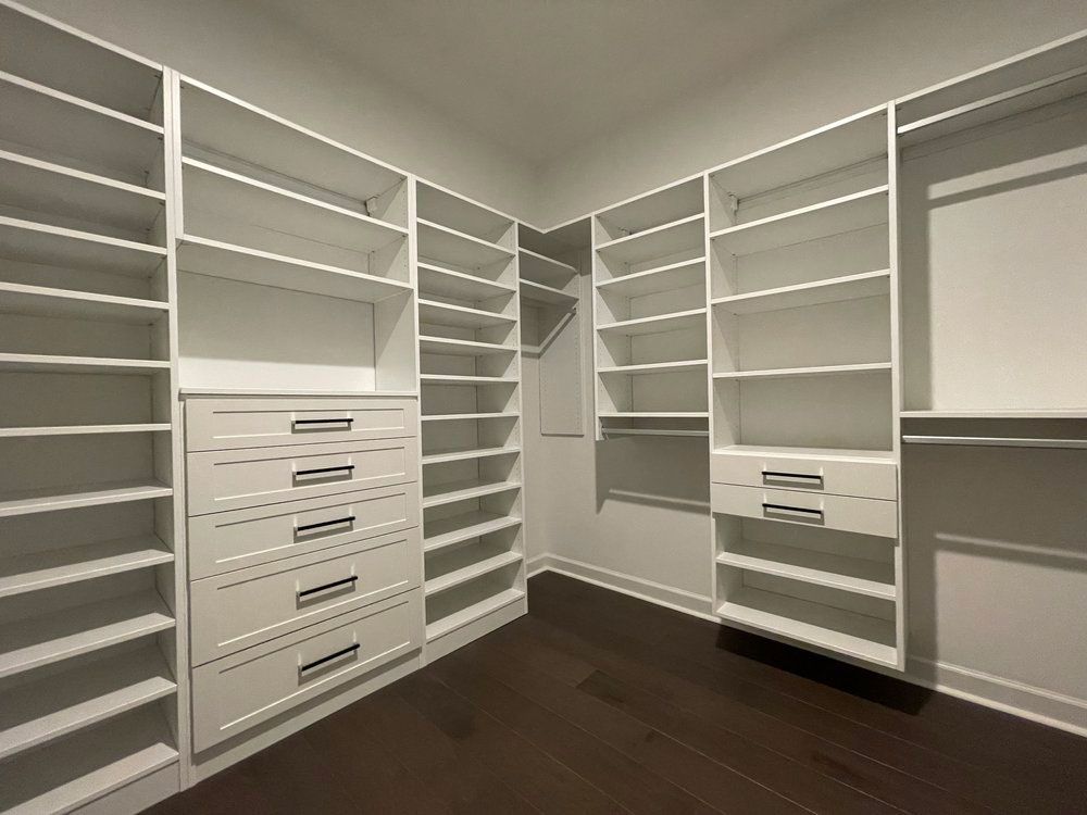 A walk in closet with lots of shelves and drawers.