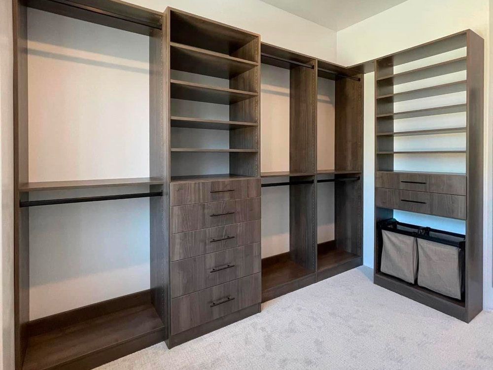 A walk in closet with lots of shelves and drawers.