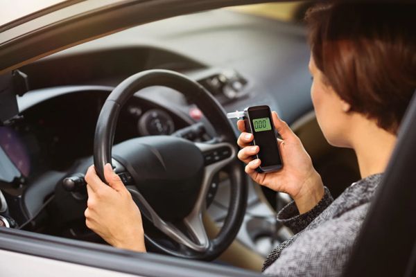 A woman inside the car using ignition interlock device