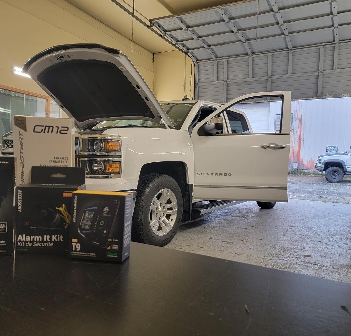 a white truck is parked in a garage with its hood open