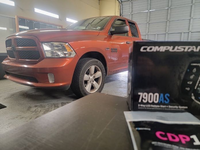 a dodge ram truck is parked next to a compustar cdp1 box .