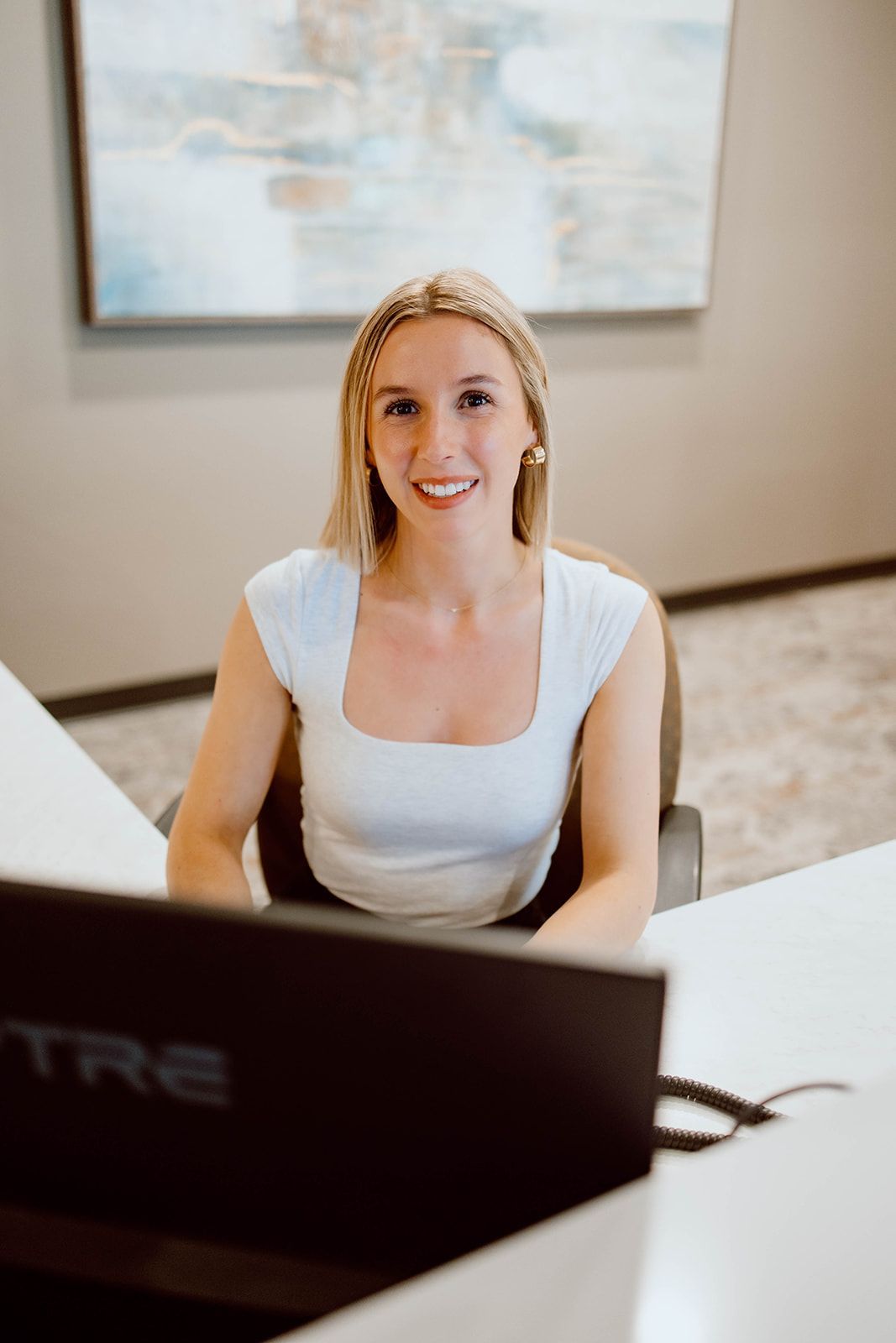 A woman is sitting at a desk in front of a computer.
