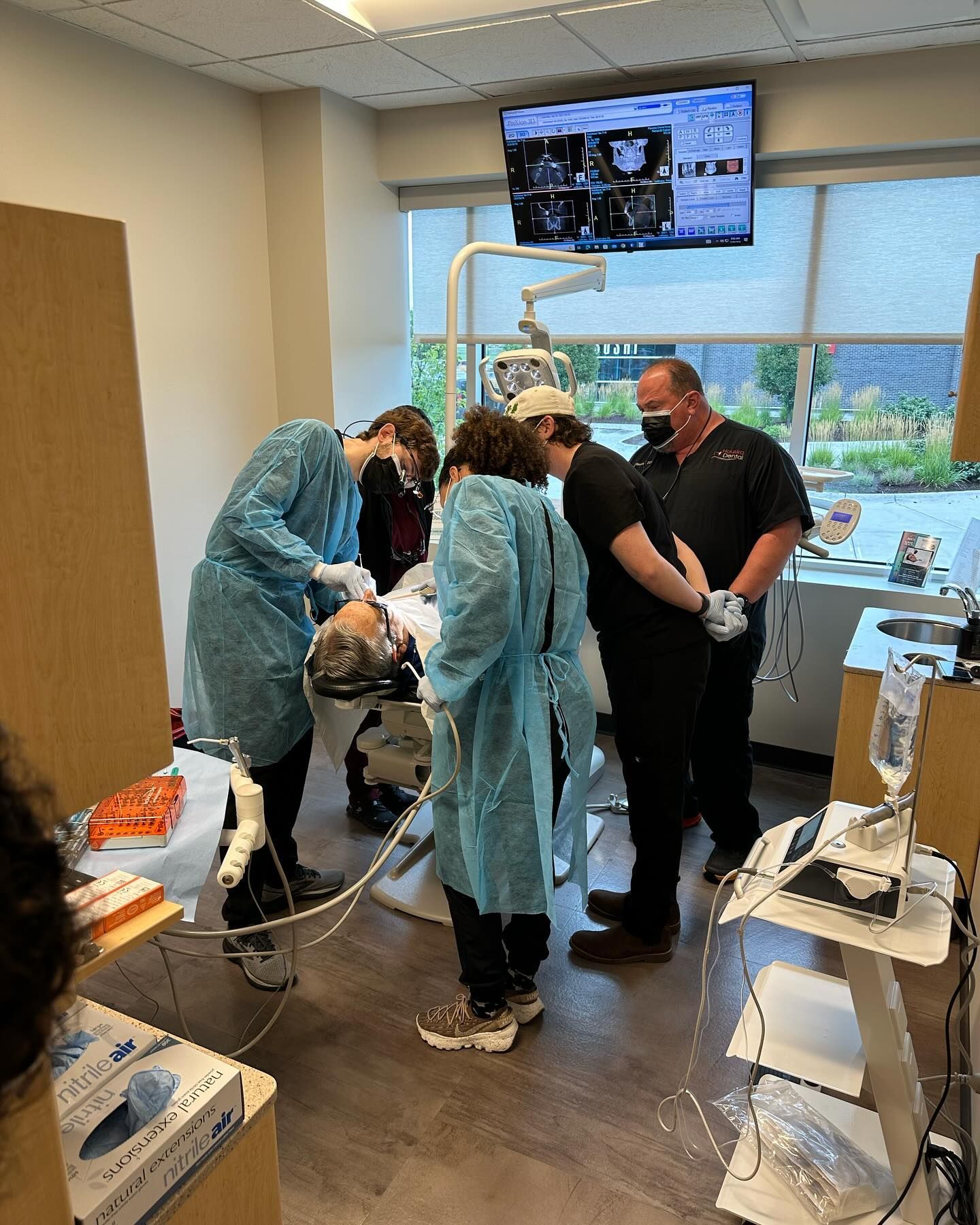 A group of dentists are working on a patient in a dental office.