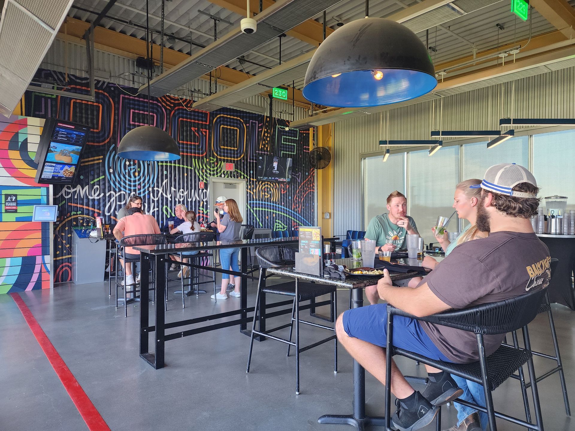People seated at tables in a colorful, modern indoor restaurant or café.
