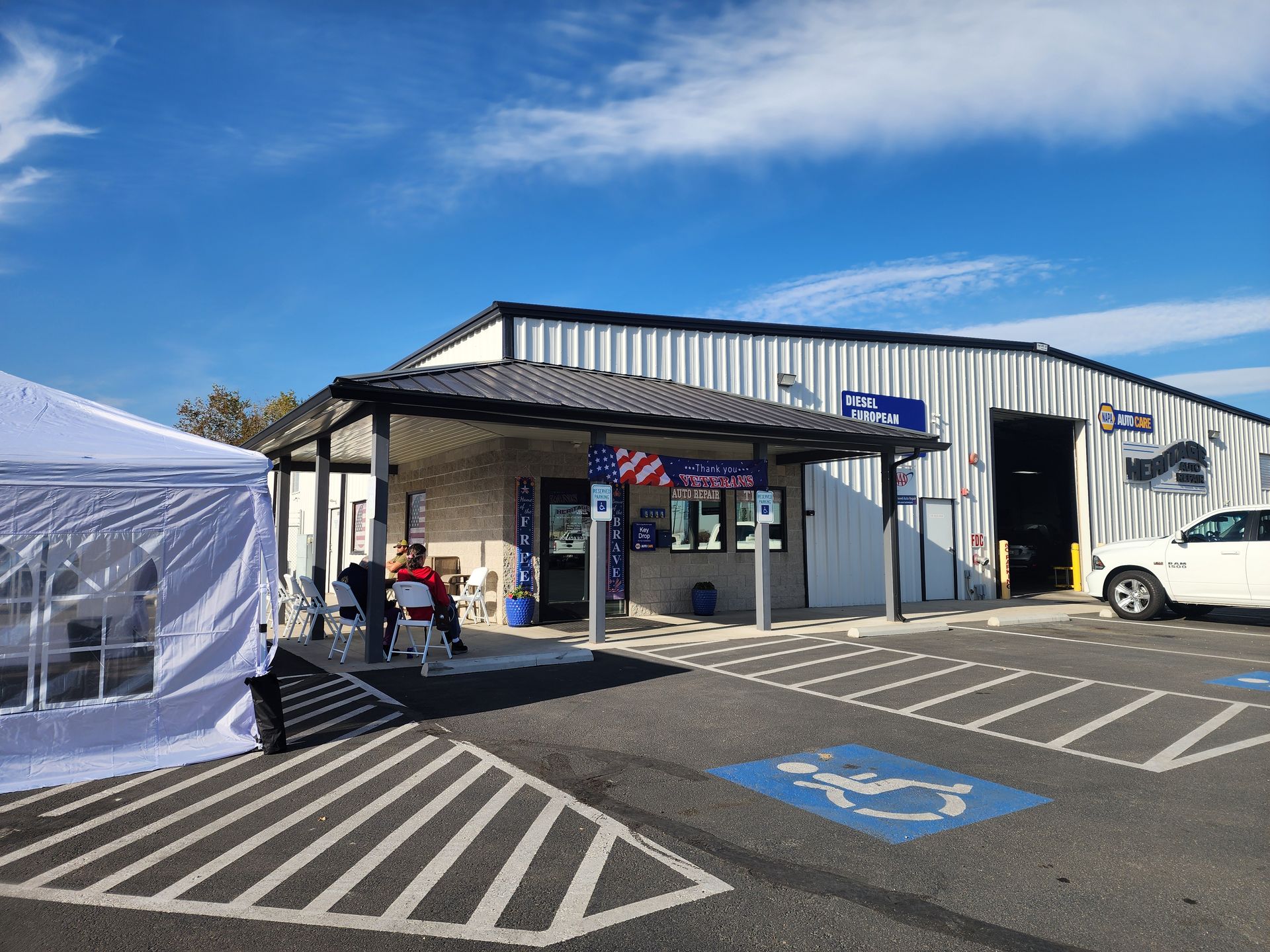 Industrial building with entrance, parked white van, and accessible parking spaces under a blue sky.