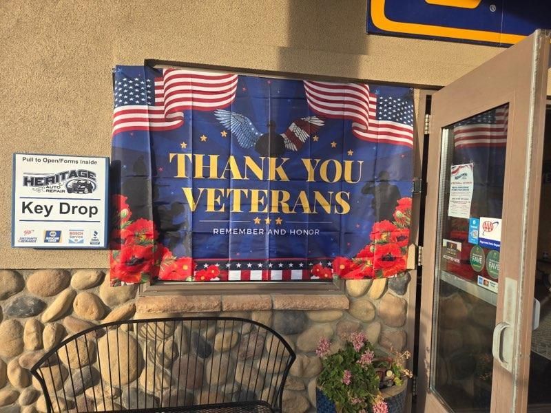 Thank You Veterans banner with American flags beside a Key Drop sign at a building entrance.