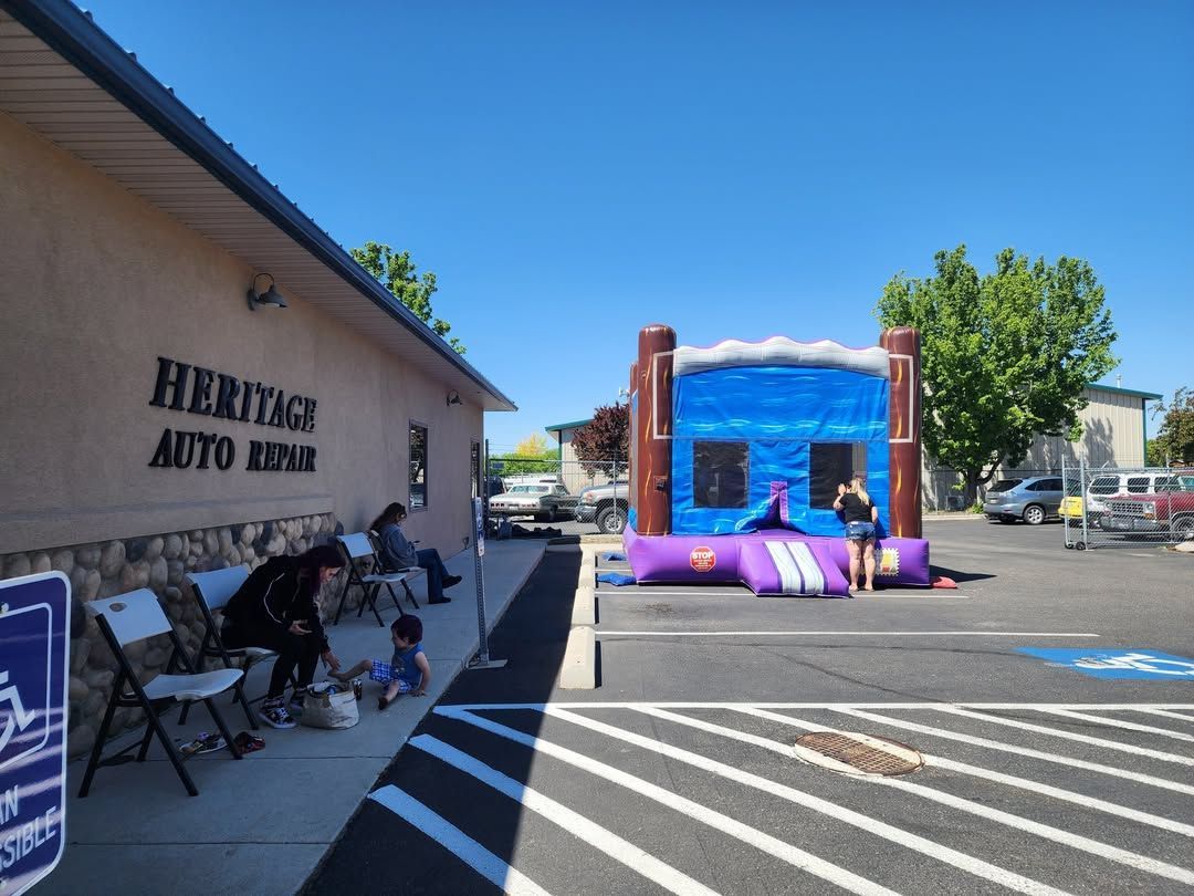 Bounce house at auto shop parking lot on a sunny day.