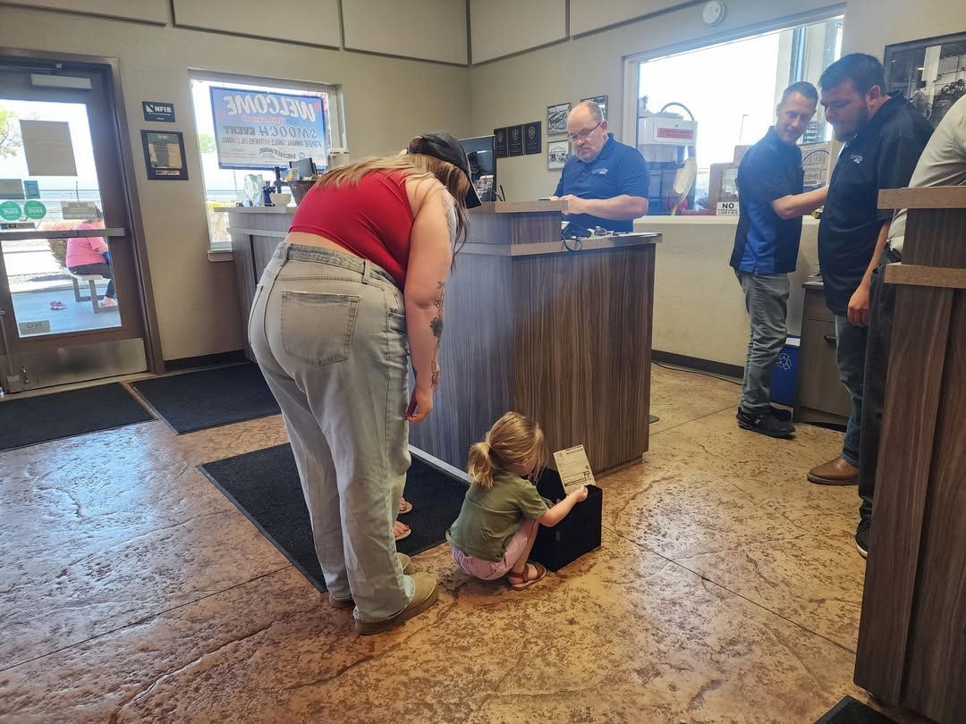 Child sitting on a restaurant floor near an adult at the counter, with people standing nearby.