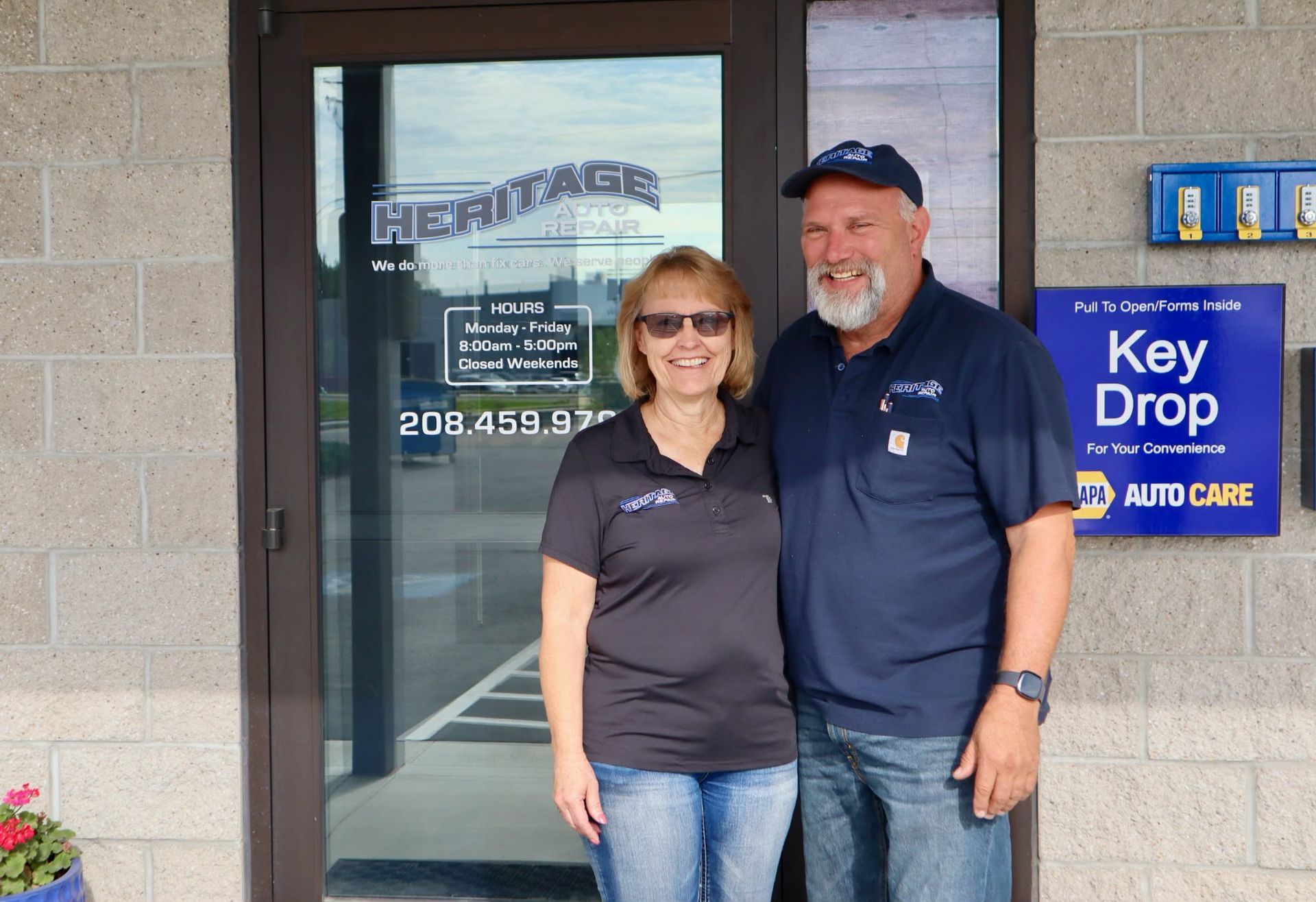 Two people standing by a glass door next to a blue Key Drop sign.