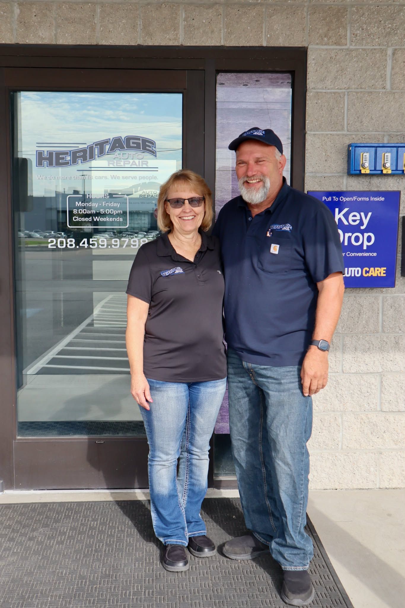 Two people standing outside a storefront entrance, smiling beside a Key Shop sign.
