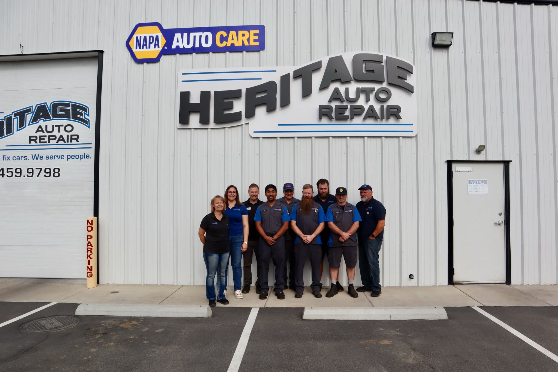 Heritage Auto Repair staff posing in front of the shop building.