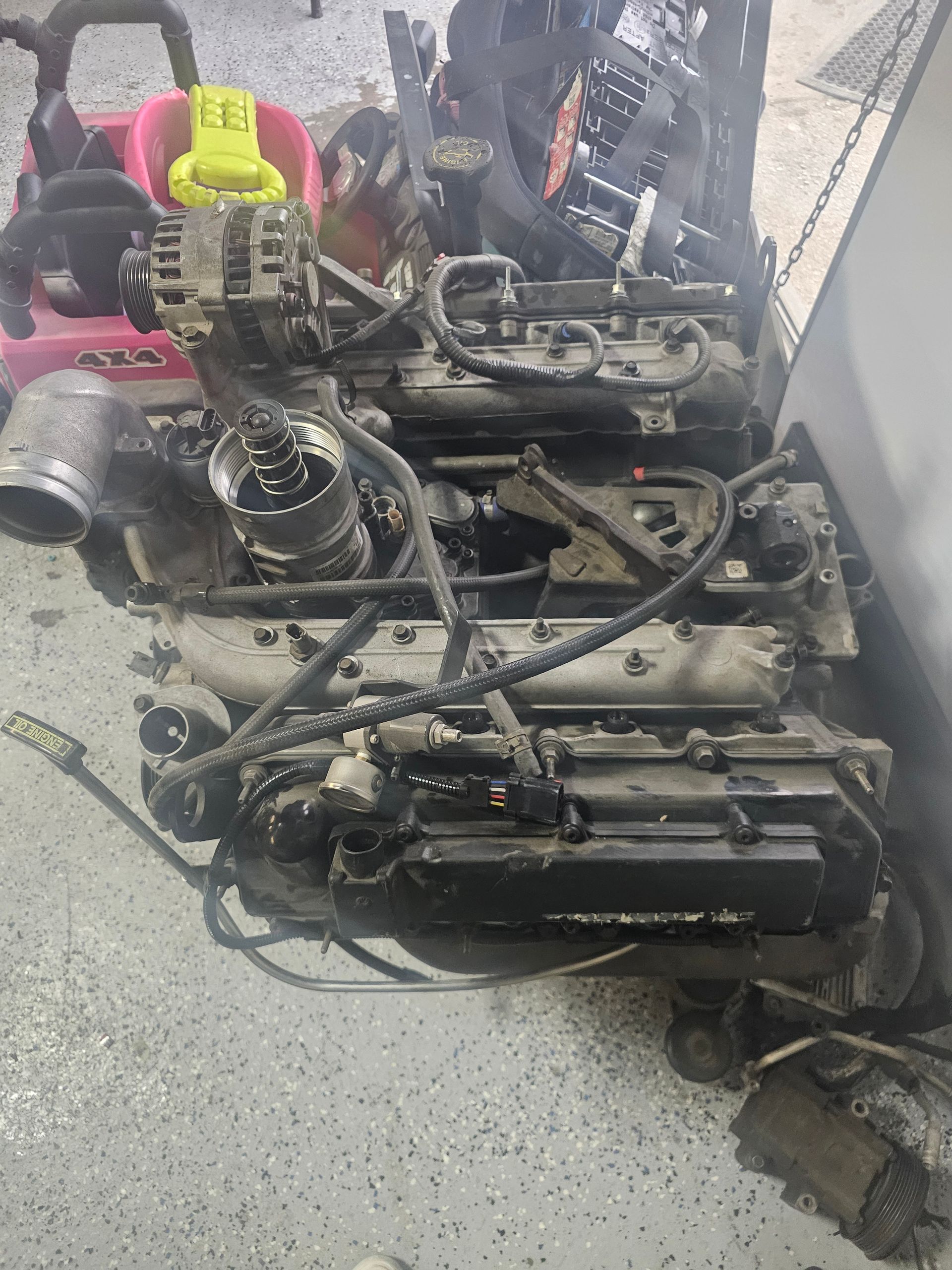 Engine assembly with various components, appearing dirty, likely from a vehicle.
