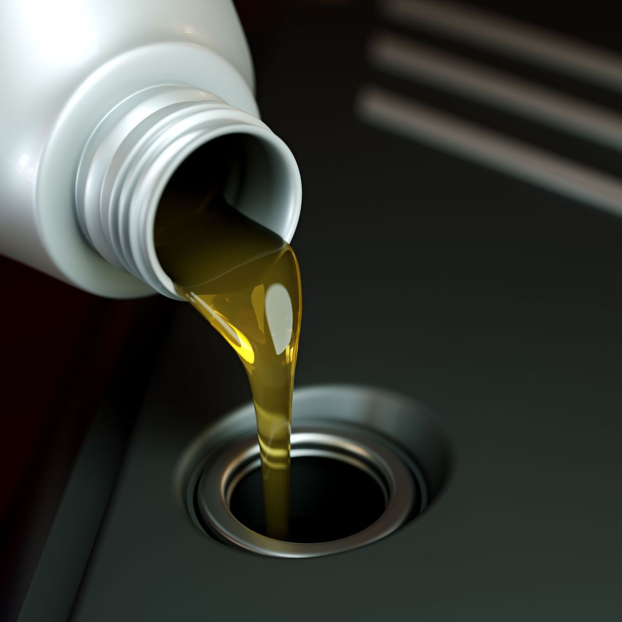 Oil being poured from a white bottle into a sink drain