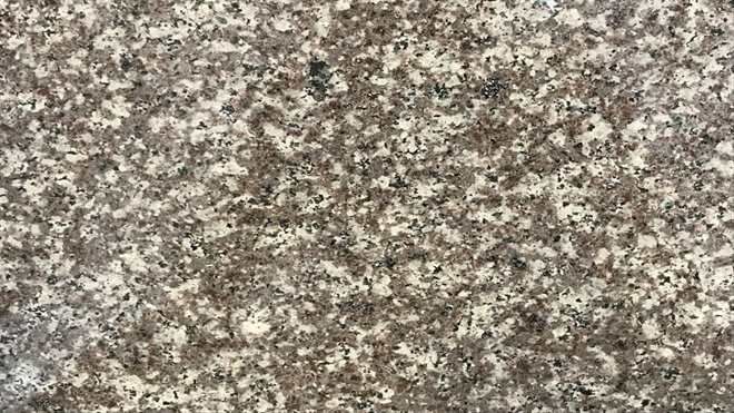 A close up of a brown and white granite counter top.