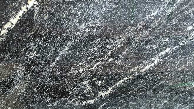 A close up of a black granite counter top.