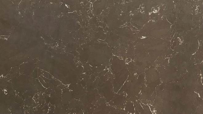 A close up of a brown granite counter top with white spots.