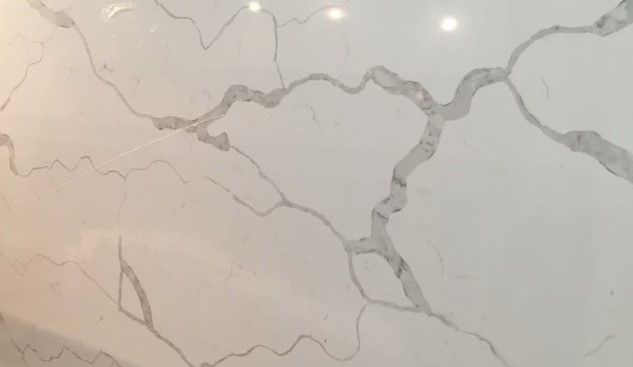 A close up of a white marble counter top with a marble texture.