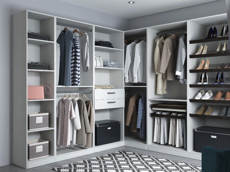 A walk in closet filled with clothes and shoes.