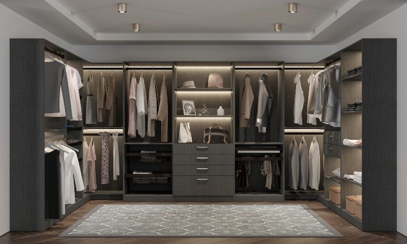 A walk in closet filled with lots of clothes and a rug.