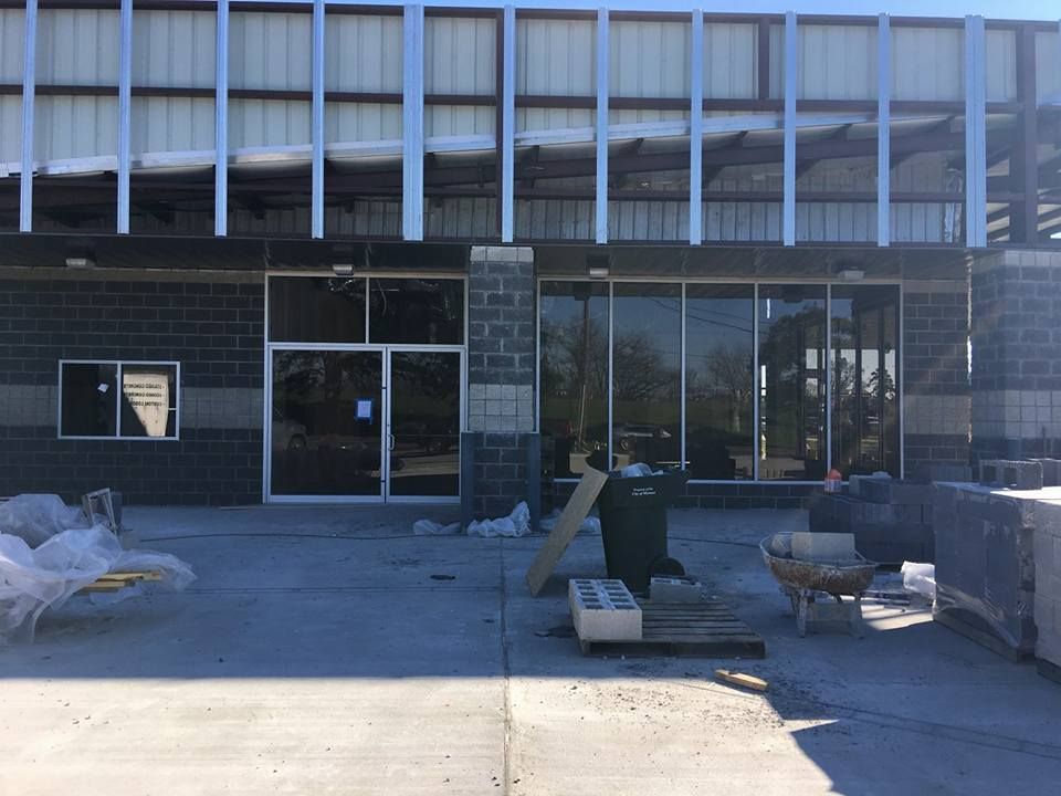 Storefront entrance with large windows and outdoor seating under construction or renovation