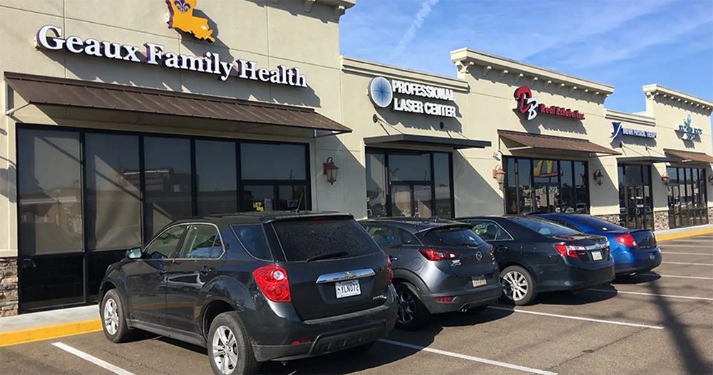 Medical office storefronts in a strip mall with parked cars in front, including Great Family Health