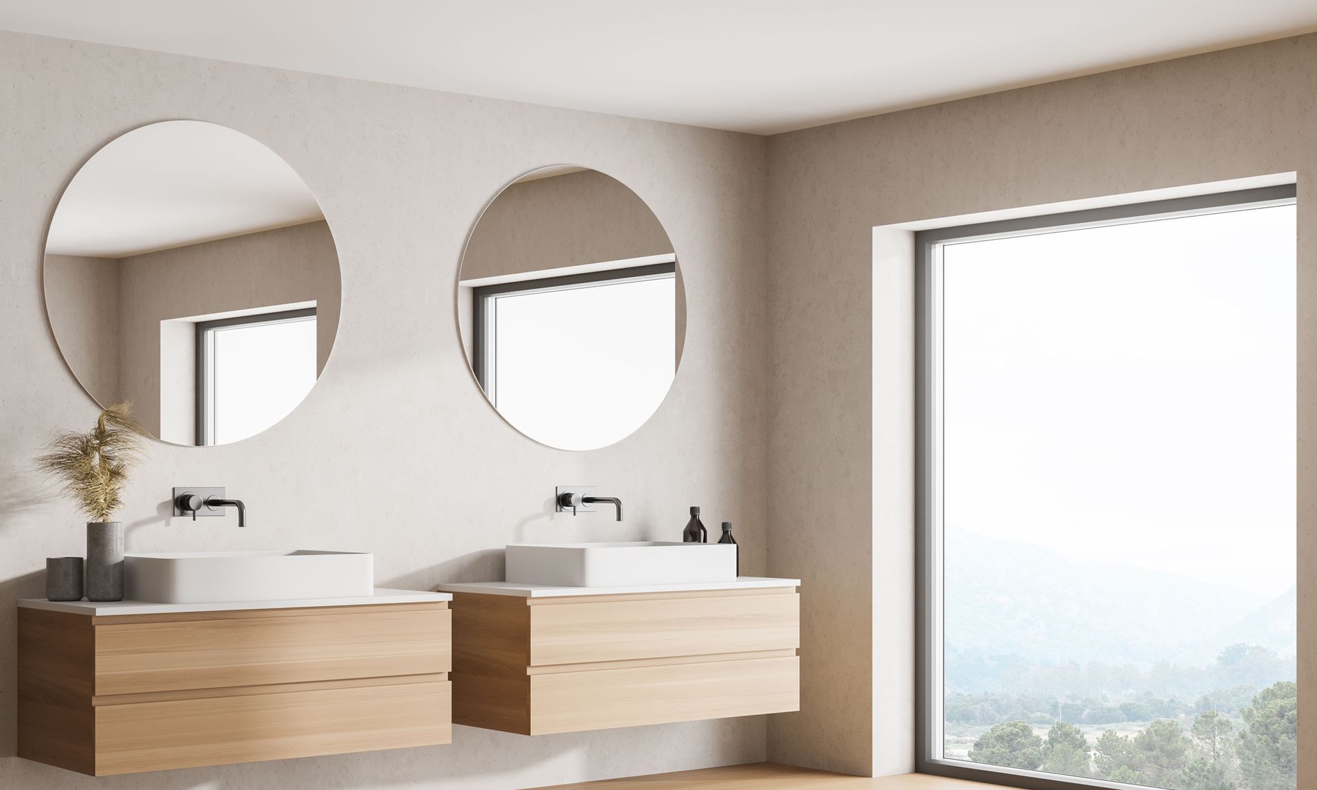 Modern bathroom with two round mirrors, wood vanities, and a large window overlooking a bright view