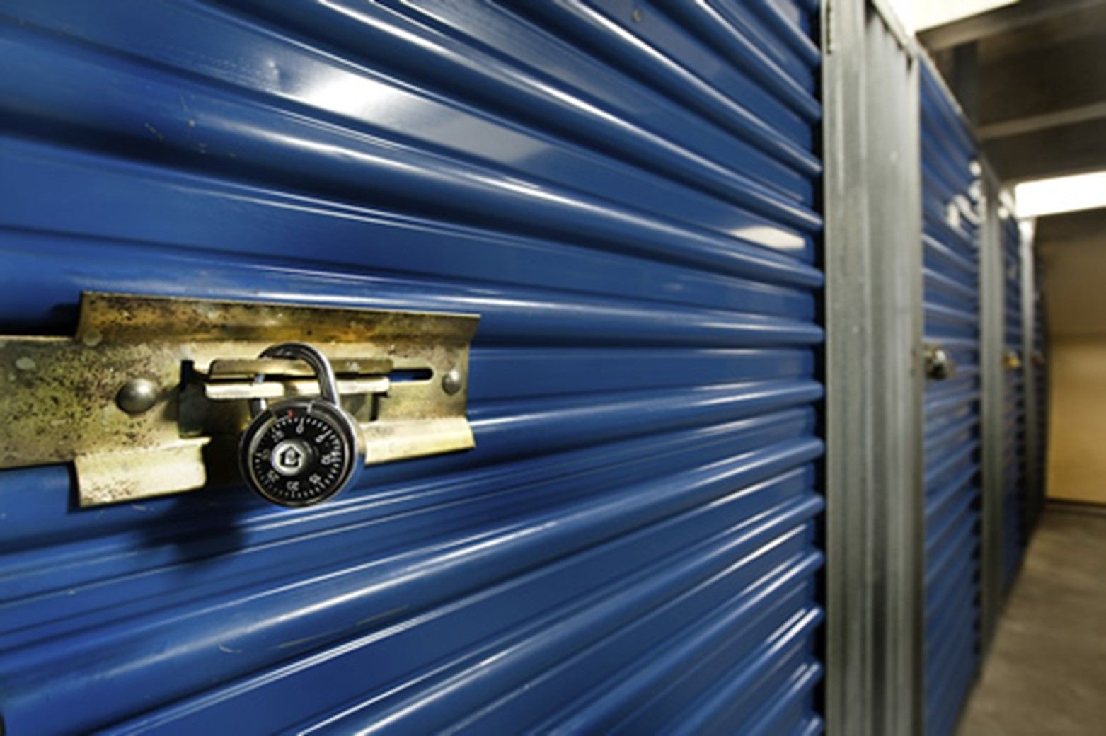 A blue garage door with a padlock on it.