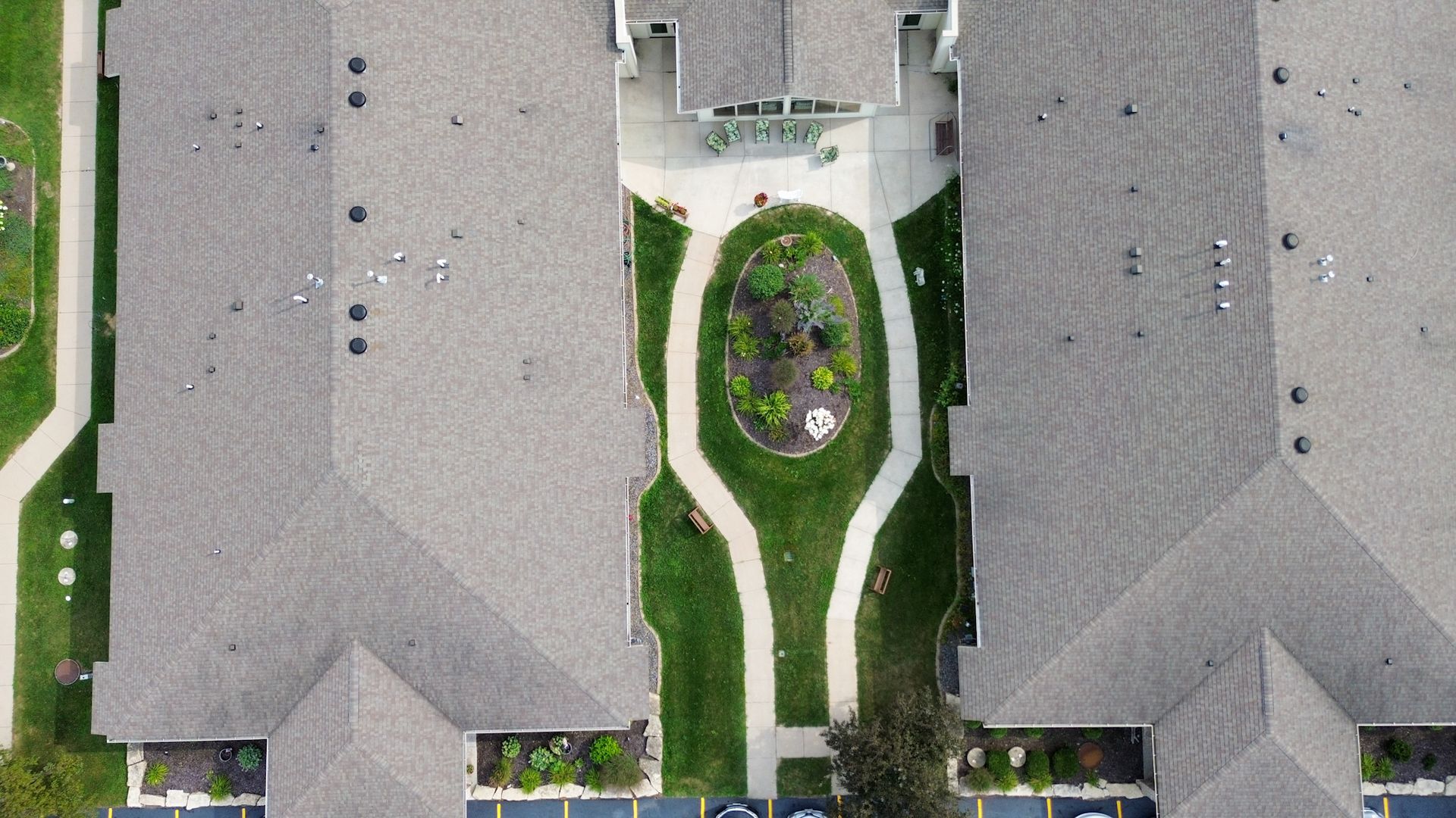Overhead view of apartment buildings with a central garden and walking paths.