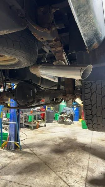 A car is sitting on a lift in a garage.