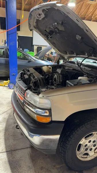 The hood of a truck is open in a garage.