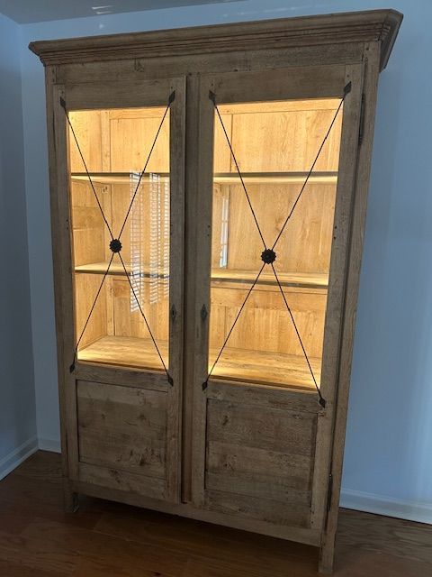 Wooden display cabinet with glass doors and interior lighting.