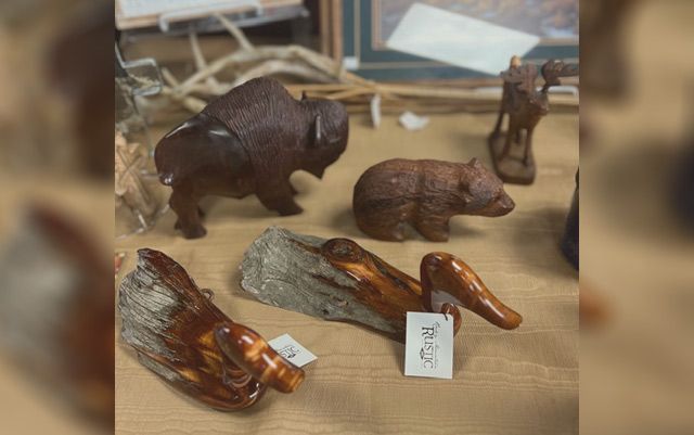 A bunch of wooden animals are sitting on a table.