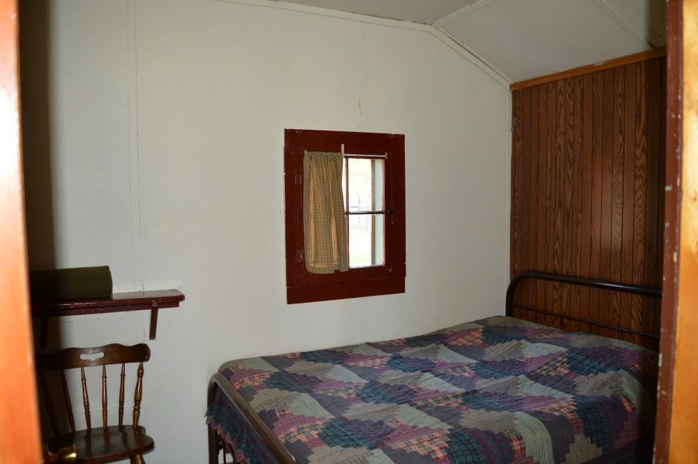 a bedroom with a bed a chair and a window