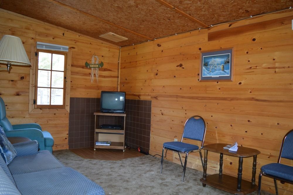 a living room with a couch and chairs and a television