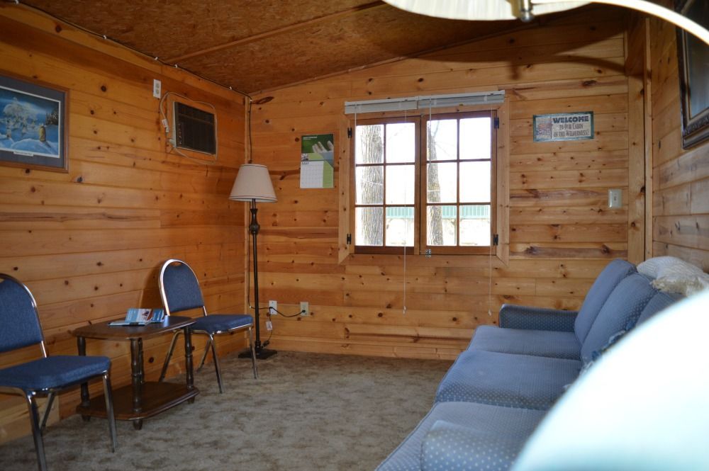 a living room with a couch, chairs, a table and a lamp
