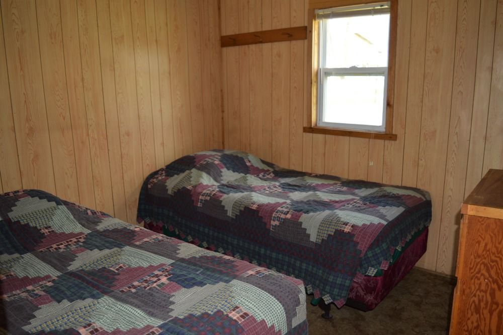 a bedroom with two beds and a window