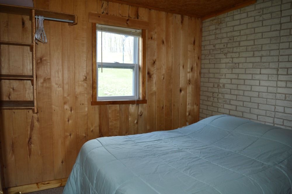 there is a bed in the middle of the room with a window